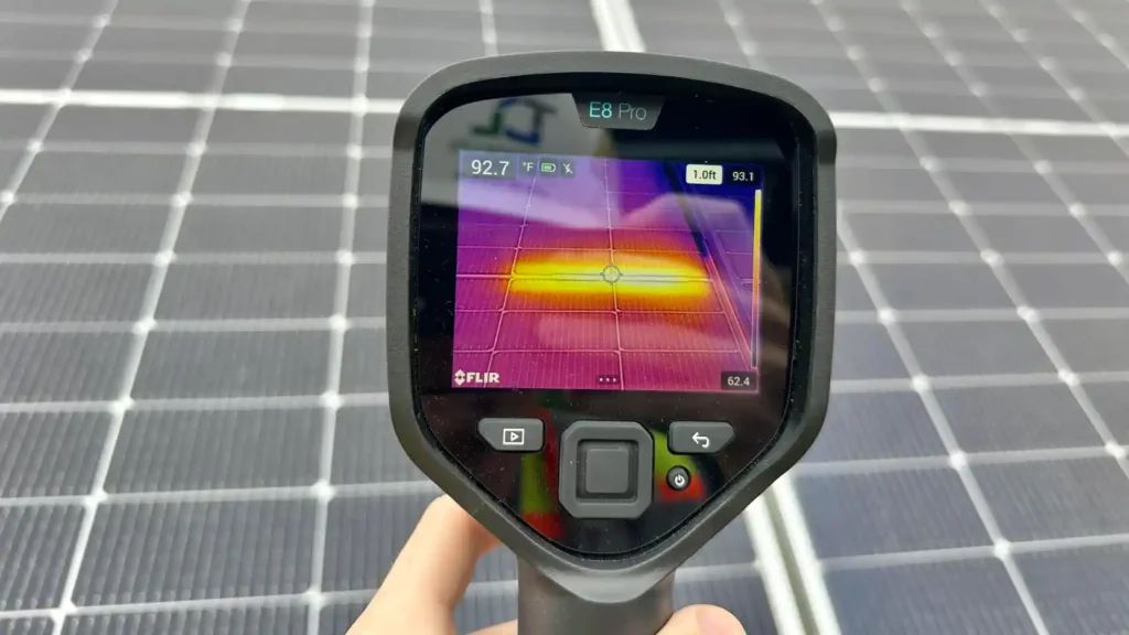 Handheld thermal camera inspecting solar panels - alternative to thermal drone survey Ireland